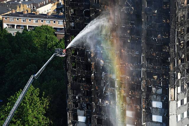FIREFIGHTERS spray water after a fire engulfed Grenfell Tower