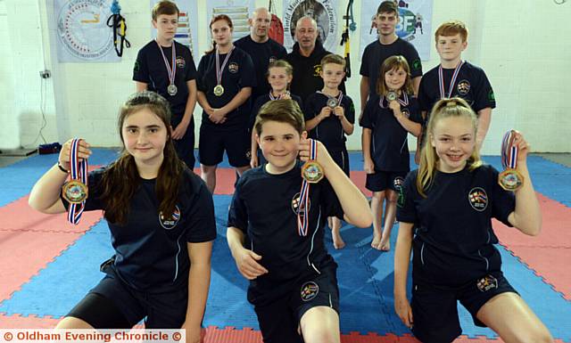 MEMBERS of Siam Camp Martial Arts who won medals in the Muay Boran Championships Front, from left, gold medal winners Melissa Sweeney (11), brother Michael (12) and Katie Bowers (12) with other medal winners behind. Back row centre is Grand Master Kevin Lloyd
