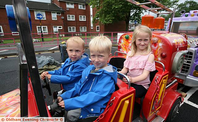 FUN ride . . . From left, Fletcher (2) Finley (3) and Faith Dissington enjoy the fire engine fun fair ride.