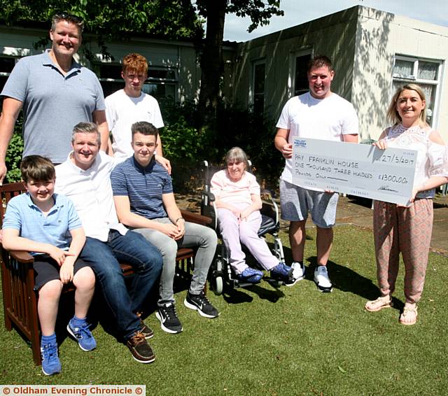CHEQUE . . . Kevin Longdon presents a cheque to Sarah Horsfield manager of Franklin House, watched by members of Paula White's family and bike riders as well as care home resident Mary Race

