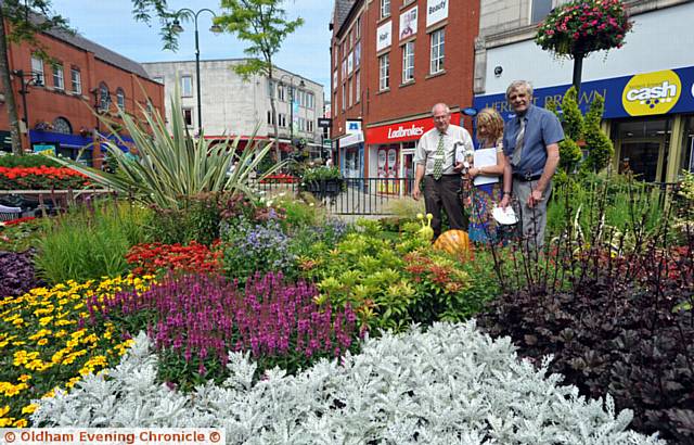judgement day . . . North West in Bloom judges in Oldham town centre looking at the Bloom and Grow display (from left) Brian Whalley, trainee judge Sarah Hawkins and Malcolm Eubank
