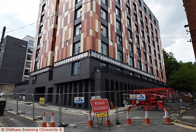 Micro flats on Rhodes Street, Oldham. Cladding being removed by workmen.
