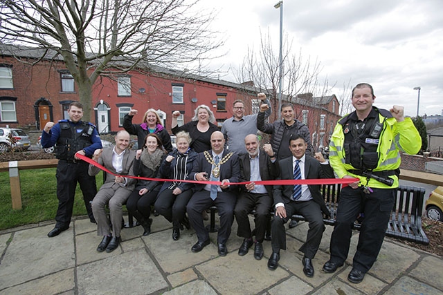 Happy days in Coppice: From left to right, front row - Ryan Smith (Great Places); Claire Molden (Great Places); Sheila Bishop (Great Places); Mayor of Oldham, Councillor Shadab Qumer; Cllr Fida Hussain; Masood Chaudry (Great Places). Back Row - Jan Wade (Great Places); Tina Loving (Greenfingers); Dave Stewart (Great Places); Naseem Ahmad (Great Places). Holding the red tape is (left) PCSO Renshaw and (right) PCSO Quarnby.