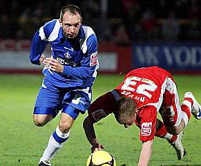 OFF WE GO: Athletic midfielder Mark Allott leaves Cheltenham Town’s Jonathan Hayes trailing in his wake. 