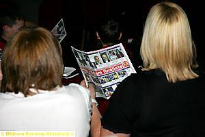Guests look at the programme to see the line-up of finalists 