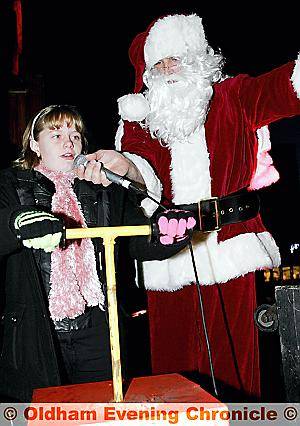 Santa and a little helper switch on the lights in Uppermill 