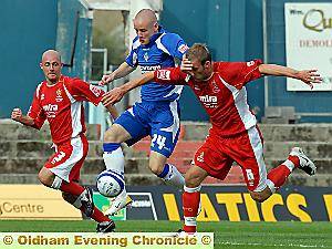 LET ME THROUGH: Deane Smalley (left) nips in between two Cheltenham defenders. 
