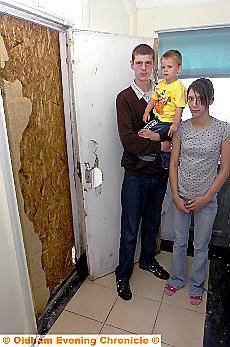 AARON WEST (20) with partner Leeanne Baker (20) and two-year-old son Leighton Baker-West and the damaged door. 