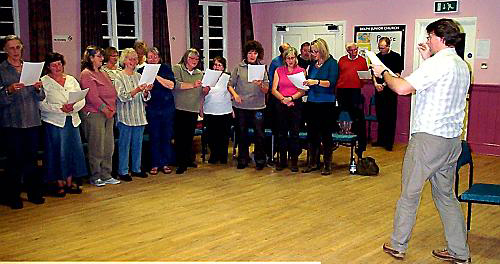 Sing UP . . . Alan Williams rehearses with some of the singers 