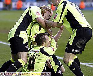 YOU’RE THE MAN: Chris Taylor is mobbed by team-mates after scoring a last-gasp goal to seal a 3-2 win at Millwall on Saturday.