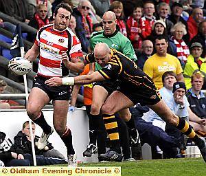 Oldham’s Danny Halliwell looks inside as Graham Holroyd gets in a tackle. 