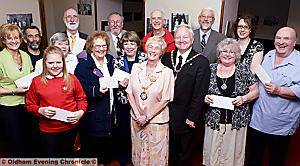 PRESENTATION time . . . outgoing Saddleworth parish chairwoman councillor Pat Lord (centre) with husband councillor Brian Lord handing out cheques to local charities 