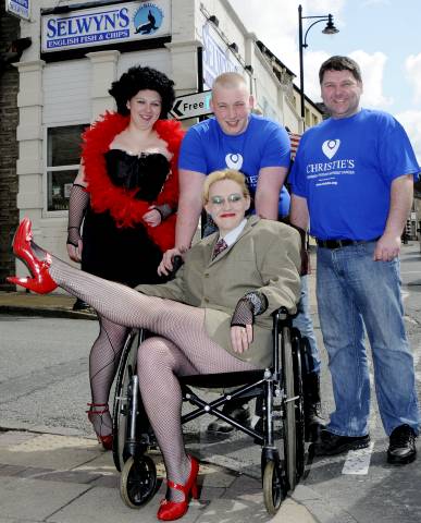 Chris Marshall (centre) pushes his mother, Lesley, in a wheelchair in a dress rehearsal for the beer walk. With them are Chris’s sister, Heather, and chip-shop owner Tony Seel 