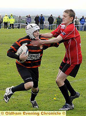GET OUT OF MY WAY: Dominic D’Adamo, of Oldham under-12s, tries to side-step a Salford opponent. 