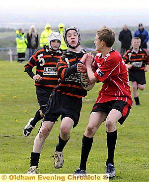 STOP RIGHT THERE: Dominic Elkin, of Oldham under-13s, runs into trouble. PICTURES by CHRIS SUNDERLAND 