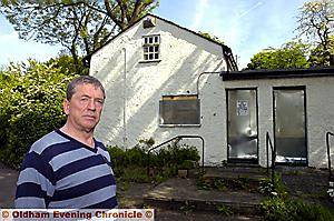 BOARDED and vandalised . . . . Paul Tucker outside the listed cottage in picturesque Daisy Nook 