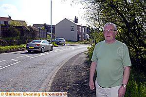 DANGER bend . . . Alan Sweeting at the accident blackspot with his house in the background 