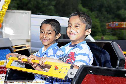 Six-year-olds Muhammad Junayd and Muhammad Navaya enjoy a carnival roundabout 
To buy this picture, call us on 0161 622 2130