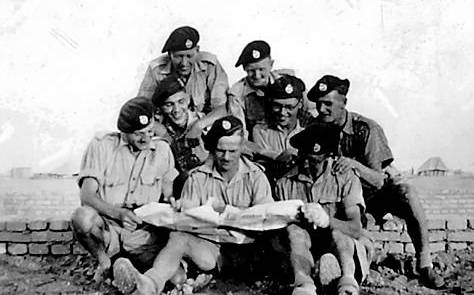 CALM before the storm . . . tank regiment members read the Oldham Chronicle before the battle: (from left, top) Cpls Wild and Stuttard, (centre) Trooper Keates and Lance Cpls Hoyle and Kelsall, (front) Troopers Mitchell and Fox, and Lance Cpl Gleave.