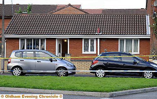 The neat bungalow where Amran Khan was shot. The silver car was later taken away by police 