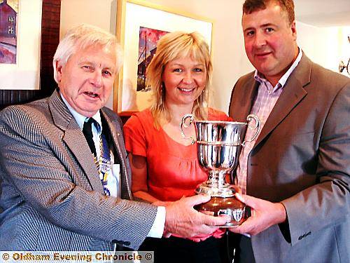 Steve Crowther and his wife, Gillian Crowther, received a special trophy for the best trade stand at the recent highly-acclaimed Saddleworth Summer Show from Club President Malcolm Hill (left).