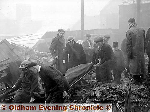 WOUNDED . . . a casualty is carried from the rubble in Abbeyhills Road 
