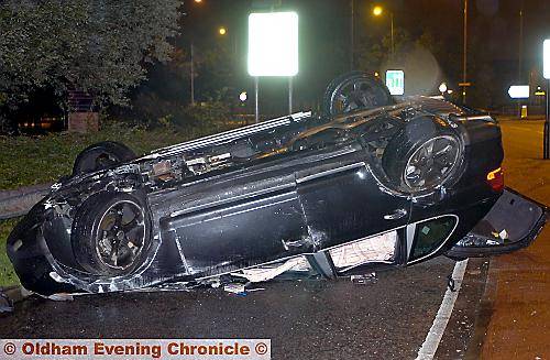 The Porsche Cayenne on its roof at the site of the crash in Featherstall Road.