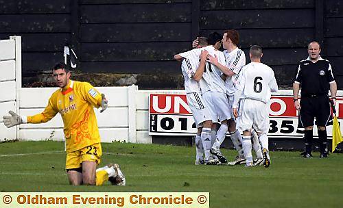 CELEBRATION . . . Mike Oates (left, partly obscured) is congratulated by his Mossley team-mates after scoring the first of his team’s two goals. 