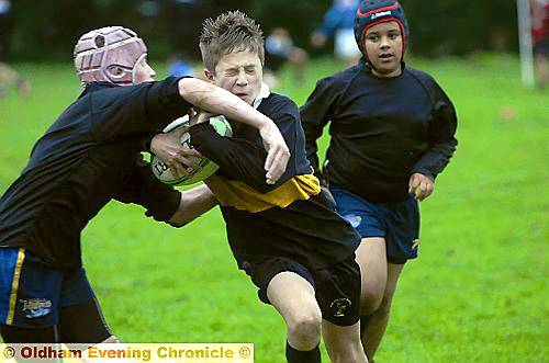 BATTLE: Blue Coat School’s Clarke Smith is tackled by Alex Jobson of Waterhead Academy.