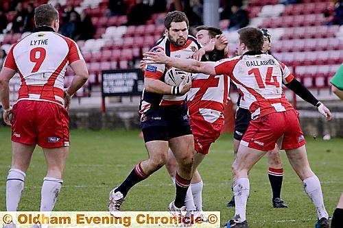 CENTRE OF ATTENTION: Oldham forward Wayne Kerr tries to fend off a Batley tackler.