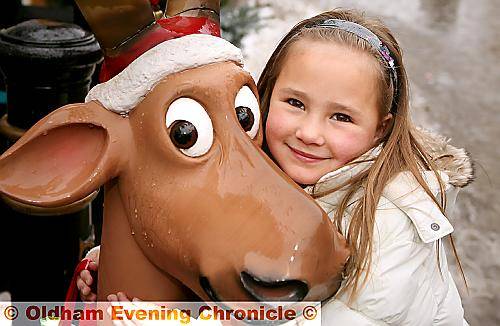 FESTIVE friend . . . five-year-old Libby Golland makes friends with a decorative reindeer  

