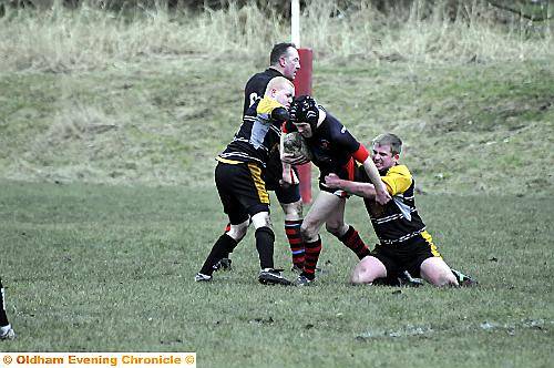 Higginshaw’s Nick Williams tries to break through the challenge of Widnes Tigers’ Danny Cooney and Martin Hill. More pictures and report on Thursday 