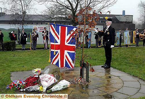 FALL silent . . . the standard is lowered as friends and family remember the dead