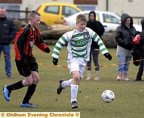 Stephen Humphries (centre), of Shaw Stars under-13s, is pursued by Chadderton Juniors FC’s Adam Marsden.