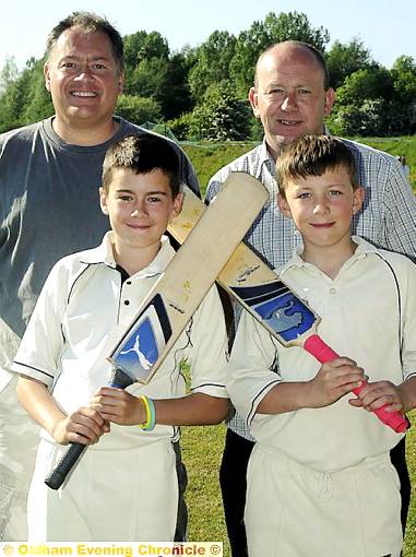 CRICKETERS James Howard (front, left) and Nathan Jones are following in their fathers’ footsteps — Steven Howard (back, left) and Grant Jones — by playing in the same Oldham town team. 