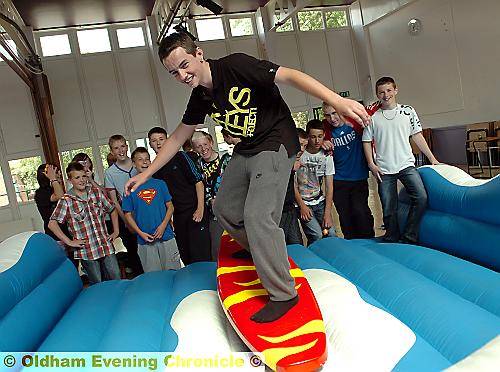 RIDING “the waves” . . . Jake Jackson tackles the surf board simulator. 