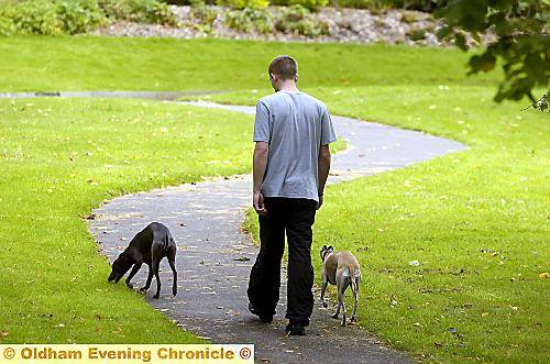 A MAN walks with his dogs off the lead in an Oldham park. Could this soon be outlawed? A MAN walks with his dogs off the lead in an Oldham park. Could this soon be outlawed?