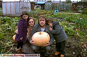 ALLOTMENT wars: Ben Carcamo with partner Natalie Muir and their children Lucy (6) and Amadeus (4), and one of the fruits of their labour — a giant pumpkin 