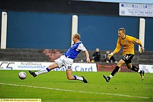 AND THAT MAKES THREE: Spireites ’keeper Ole Soderberg looks on as Simpson slots the ball home for his third of the afternoon and Athletic’s fourth. 

