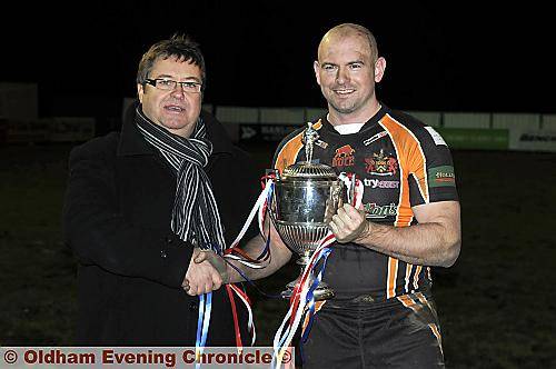IT’S ALL YOURS . . . Oldham chairman Chris Hamilton hands over the Law Cup to Neil Roden. The long-serving player is the Roughyeds captain for 2011. 