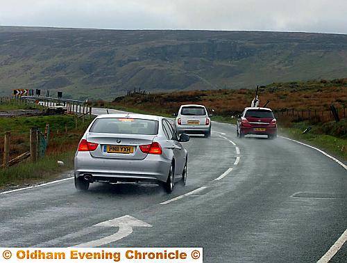 A DRIVER overtakes in wet conditions close to one of the road’s notorious sharp bends  

