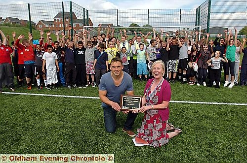 OFFICIALLY open... England international rugby star Kevin Sinfield with Carol Cawkwell, head teacher at the Hathershaw College of Technology and Sport, with pupils at the official opening of the new 3G pitch 

