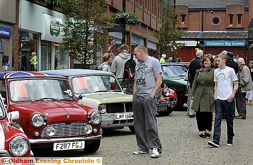 SHOPPERS and car enthusiasts pause to admire the cars. 
