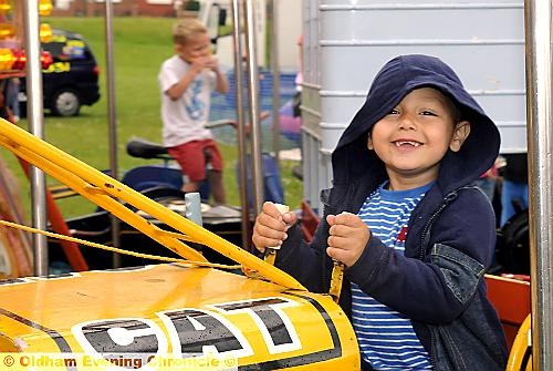 HELPFUL HOODIE... Kye Syed (3) enjoys the roundabout despite the rain showers. HELPFUL HOODIE... Kye Syed (3) enjoys the roundabout despite the rain showers.