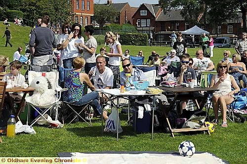 Crowds soak up the sun and enjoy the party in the park. 