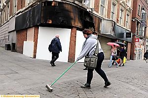 CARLY Stacey from Springhead helps sweep away the debris from the store this morning 
