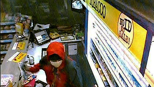 THE raider threatens the cashier with a knife 
