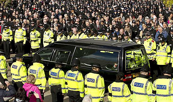 The hearse carrying murdered policewoman Nicola Hughes is driven from the cathedral as officers line the streets in tribute 
