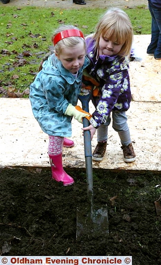 Jamie’s sister, Jodie, left, helps plant an oak tree in her brother’s memory along with niece, Lila Wrigley  

