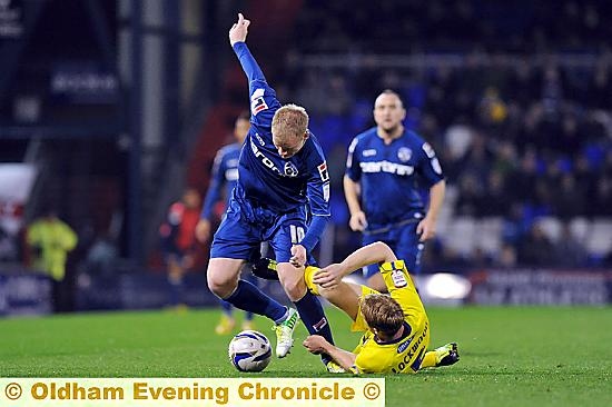 COMMITTED TO THE CAUSE: battling Robbie Simpson tries to get past Bury’s Adam Lockwood. Pictures by ALAN HOWARTH 
